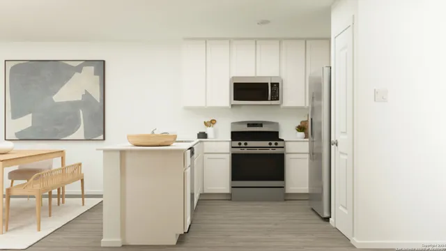 a kitchen with stainless steel appliances a stove top oven and a refrigerator