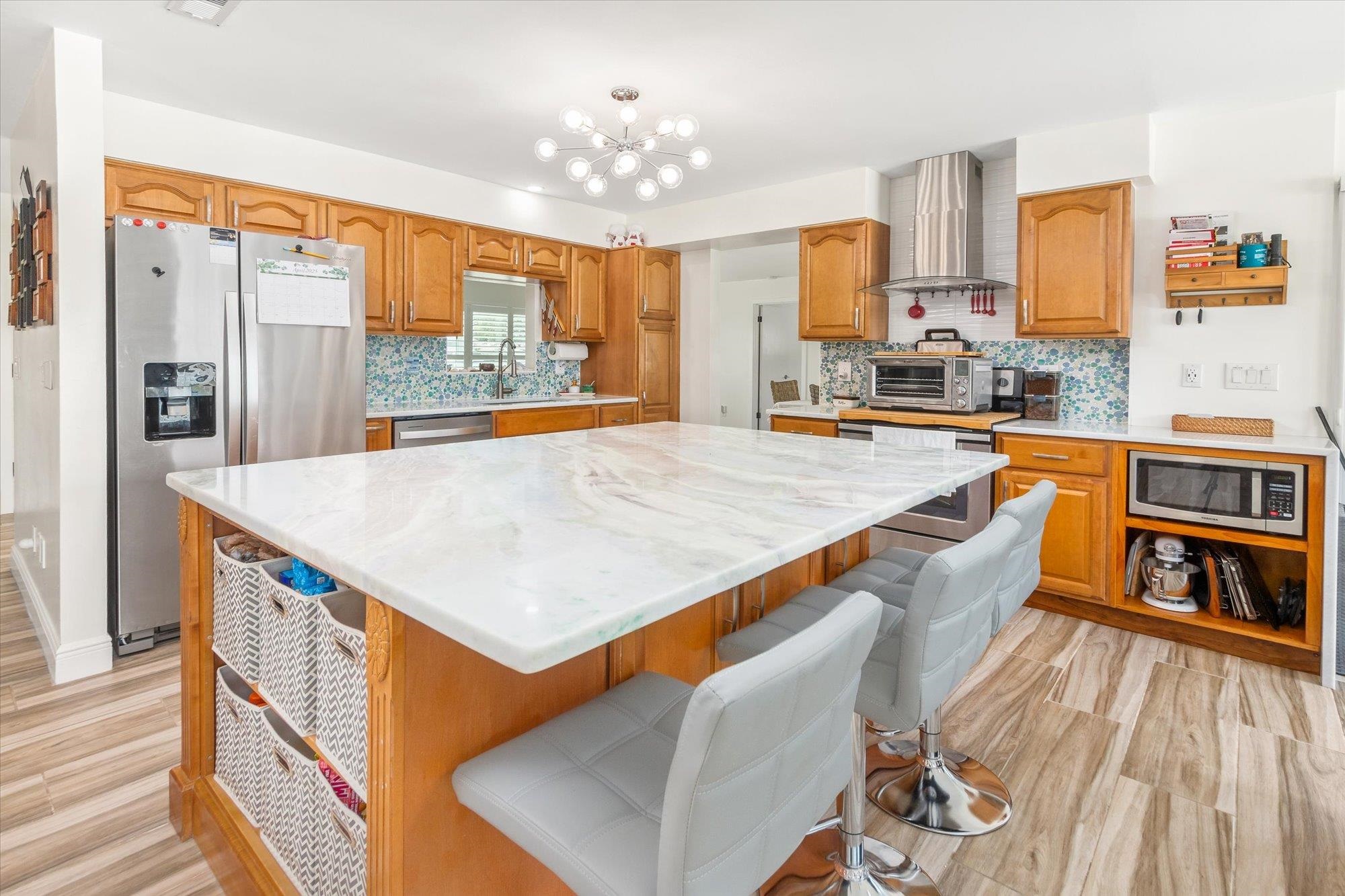5 Cheyenne Court Palm Coast, FL 32137 - Photo 12 of 58 a kitchen with stainless steel appliances a stove top oven a sink dishwasher and wooden cabinets with large windows
