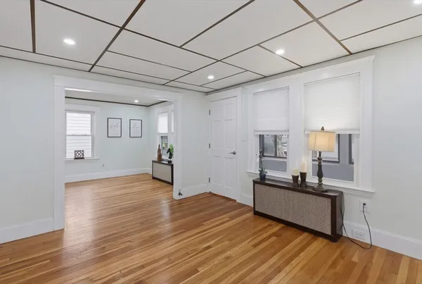 a view of a livingroom with wooden floor and kitchen space