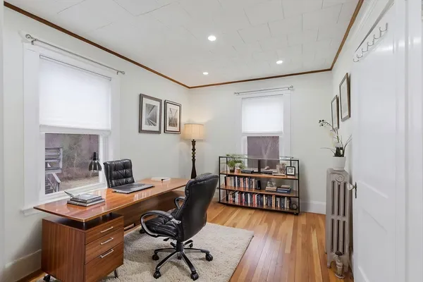 a view of a workspace with furniture and wooden floor