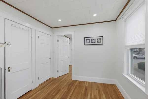 a view of hallway with a large window and wooden floor
