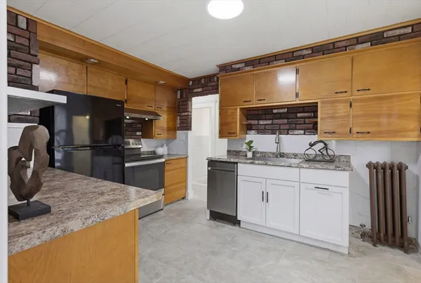 a kitchen with kitchen island granite countertop a sink cabinets and stainless steel appliances