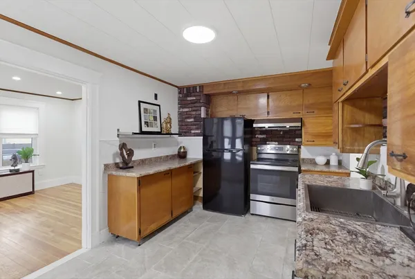 a kitchen with stainless steel appliances granite countertop a sink a stove and a refrigerator