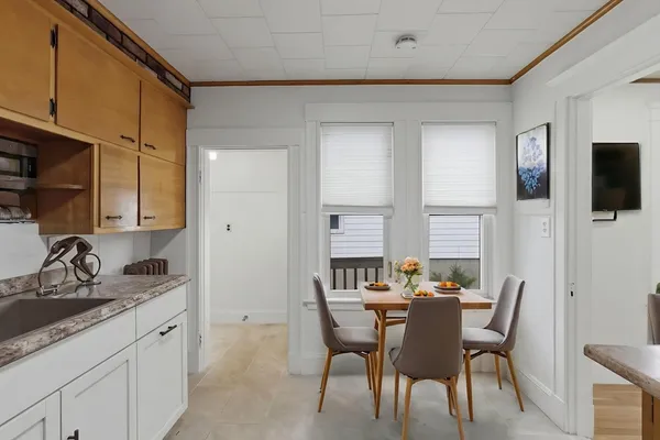 a kitchen with a sink cabinets and dining table chair