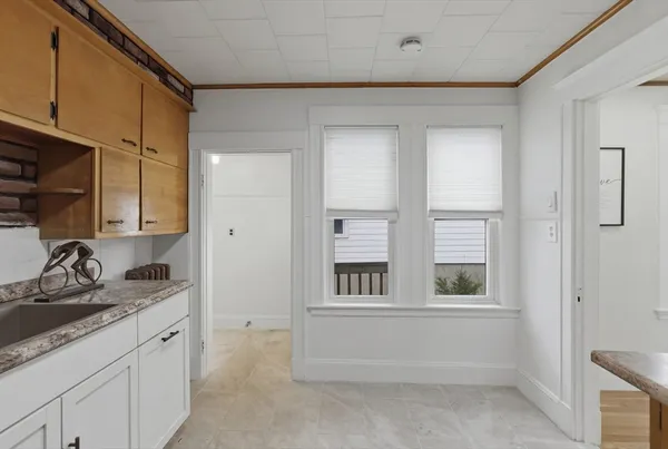 a bathroom with a granite countertop sink and a window