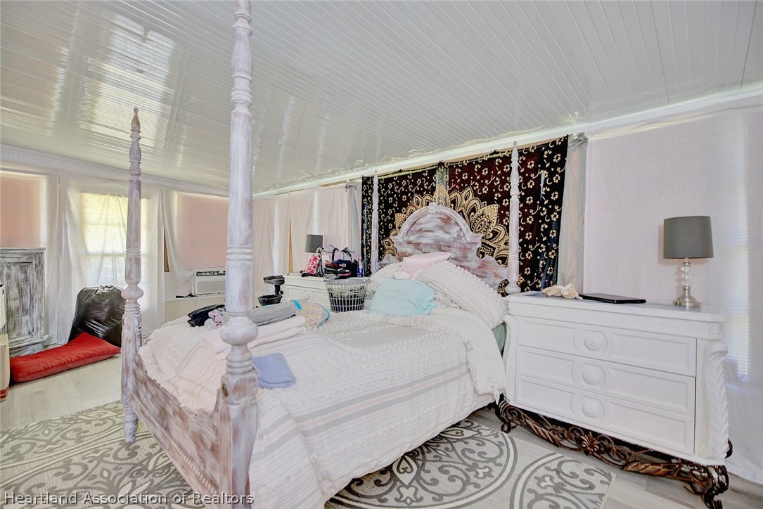 310 Pine Tree Lane Sebring, FL 33872 - Photo 11 of 28 a bedroom with a bed mirror and window