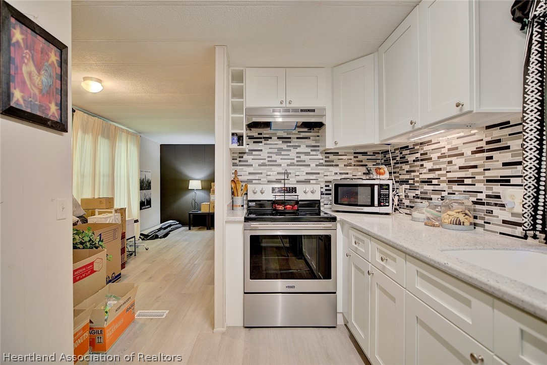 310 Pine Tree Lane Sebring, FL 33872 - Photo 17 of 28 a kitchen with kitchen island a stove a sink and a refrigerator