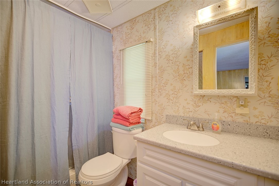 310 Pine Tree Lane Sebring, FL 33872 - Photo 21 of 28 a bathroom with a sink a toilet and shower curtain