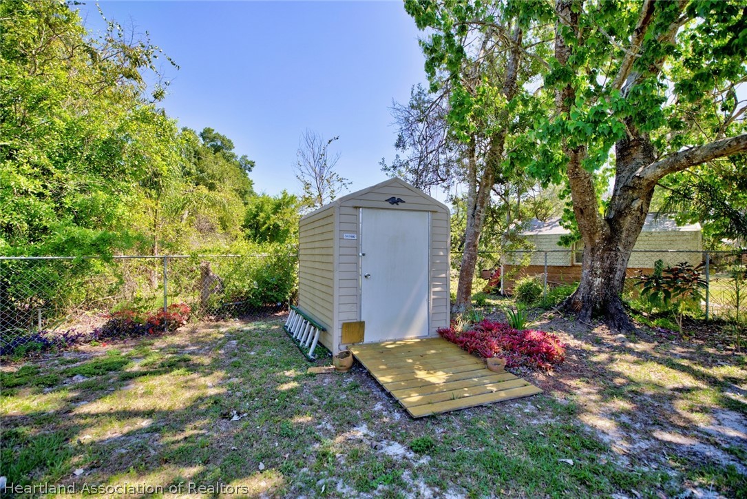 310 Pine Tree Lane Sebring, FL 33872 - Photo 25 of 28 a view of a backyard with potted plants and large tree
