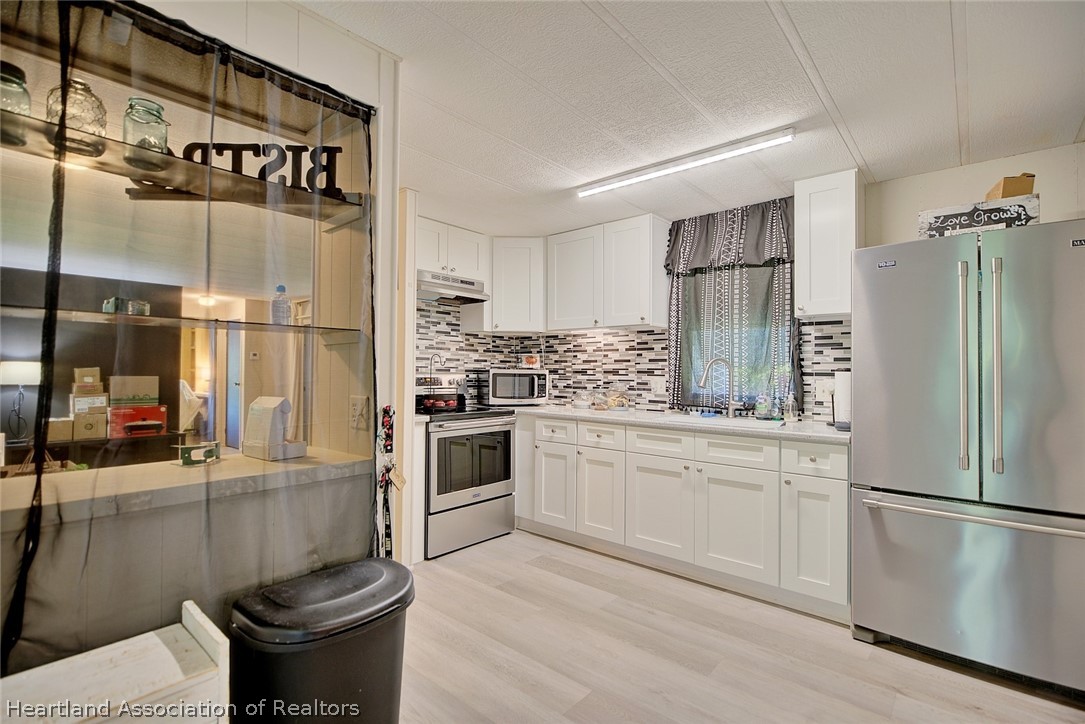 310 Pine Tree Lane Sebring, FL 33872 - Photo 4 of 28 a kitchen with a refrigerator sink and stove