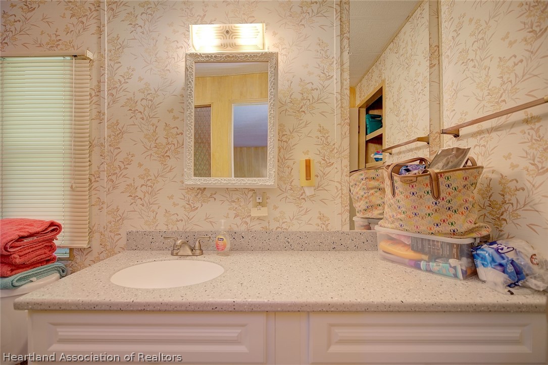 310 Pine Tree Lane Sebring, FL 33872 - Photo 6 of 28 a bathroom with a sink and a mirror
