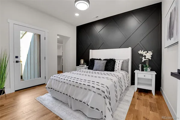 a bedroom with a large bed and wooden floor