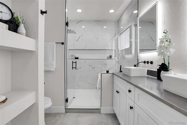 a bathroom with a double vanity sink toilet and shower