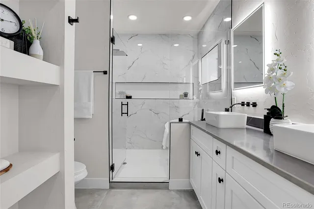 a bathroom with a double vanity sink toilet and shower