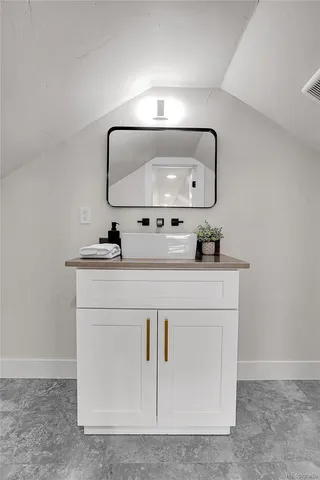 a bathroom with a sink vanity and mirror
