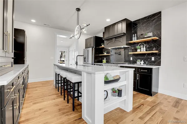 a kitchen with stainless steel appliances granite countertop a refrigerator and a stove top oven