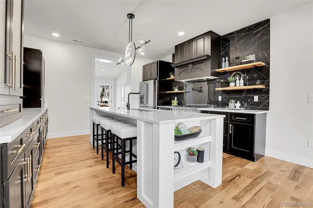 a kitchen with stainless steel appliances granite countertop a refrigerator and a stove top oven