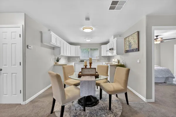 a kitchen with a white stove top oven and white cabinets