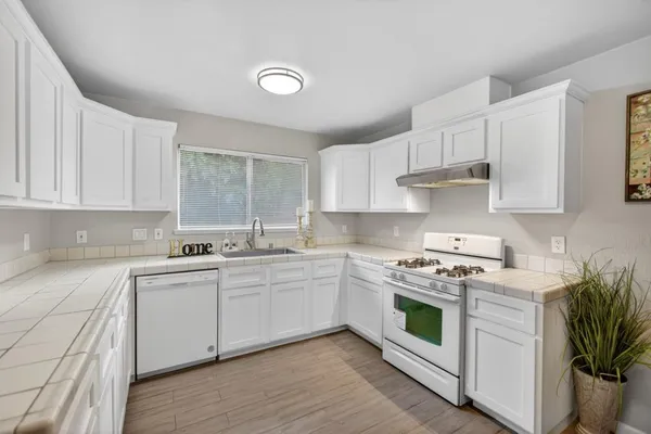 a kitchen with sink cabinets and wooden floor