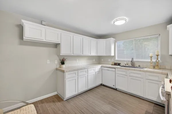 a view of a hallway with wooden floor and a bathroom