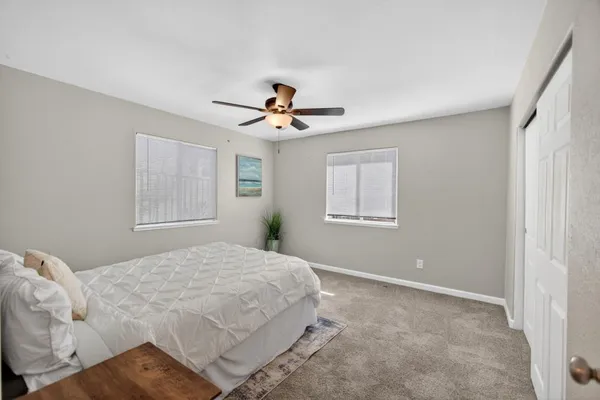 a bedroom with a large bed and a ceiling fan
