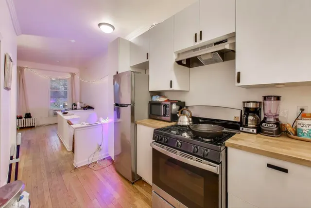 a kitchen with granite countertop a sink cabinets and stainless steel appliances