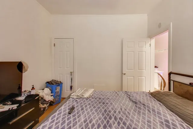 a bedroom with a bed and a computer on the desk