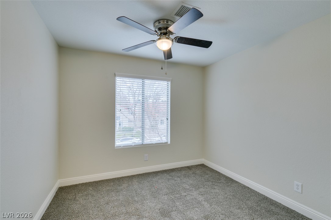 1738 Toltec Circle Henderson, NV 89014 - Photo 40 of 46 A quiet secondary bedroom features a ceiling fan, a window, and soft carpeting.