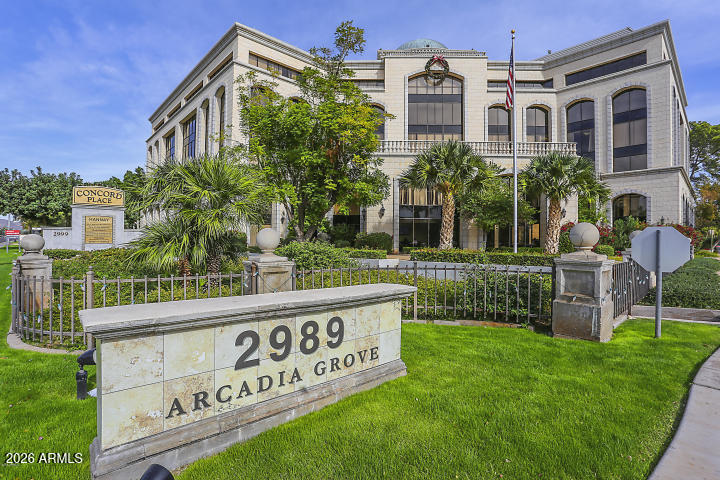 a view of a brick building with a yard and table and chairs