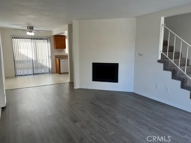 a view of a livingroom with wooden floor and a ceiling fan