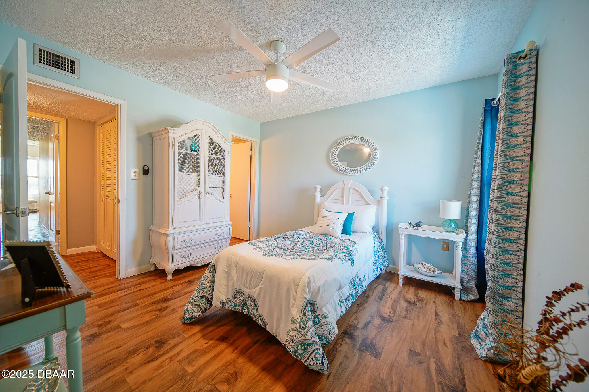 4590 South Atlantic Avenue, Unit 247 Ponce Inlet, FL 32127 - Photo 16 of 36 a bedroom with a bed and a chandelier