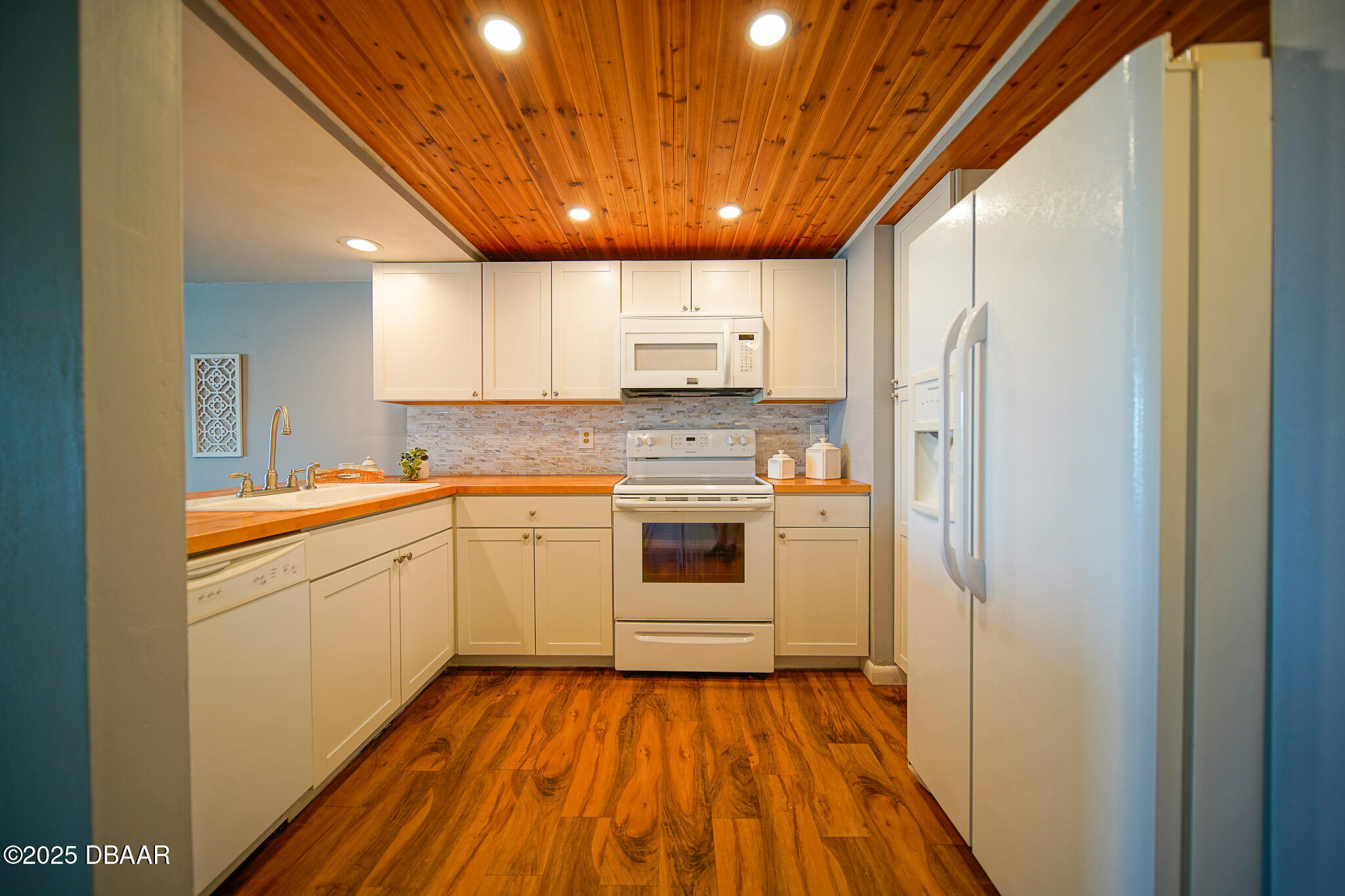 4590 South Atlantic Avenue, Unit 247 Ponce Inlet, FL 32127 - Photo 21 of 36 a kitchen with a refrigerator sink and cabinets