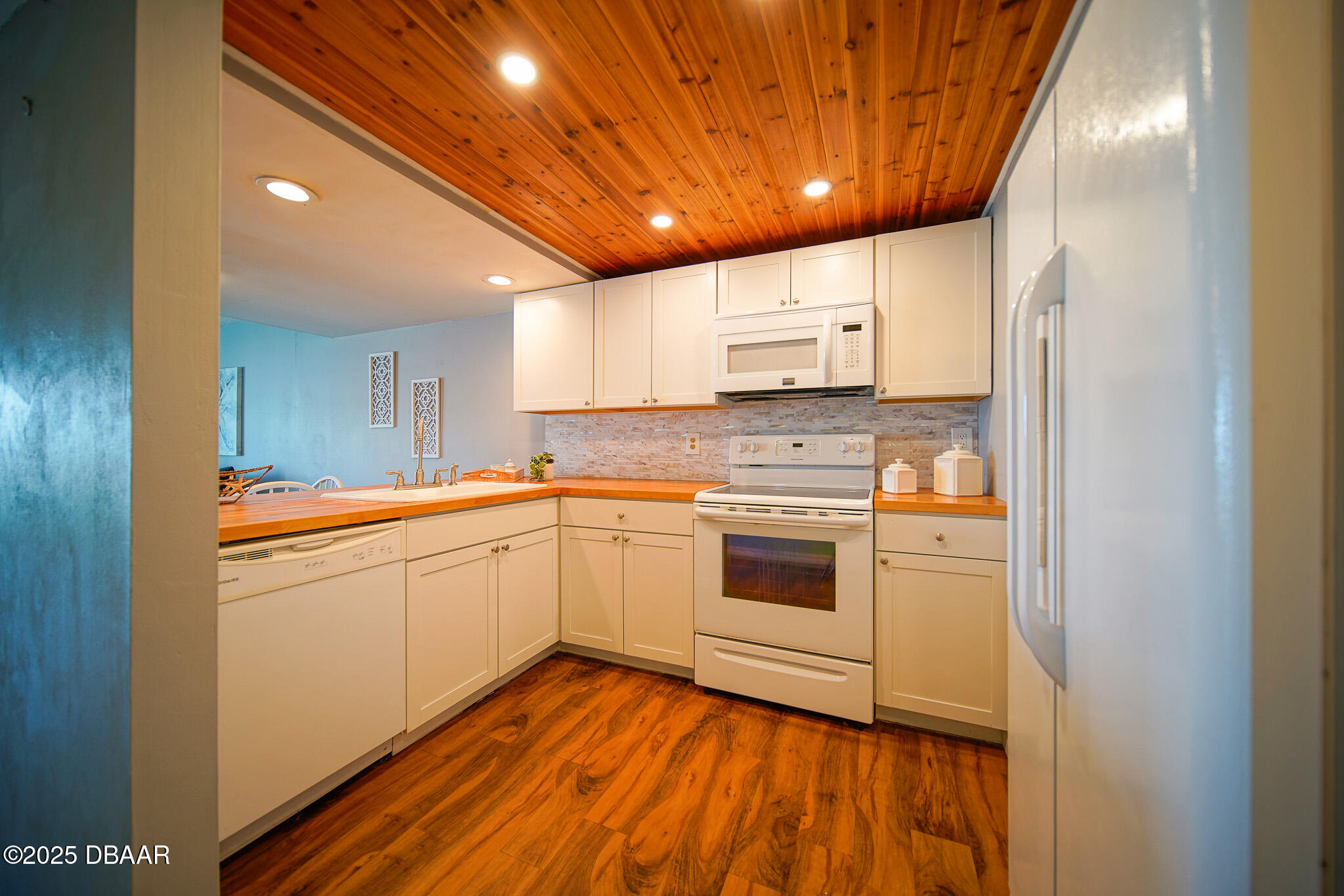 4590 South Atlantic Avenue, Unit 247 Ponce Inlet, FL 32127 - Photo 22 of 36 a kitchen with stainless steel appliances granite countertop a sink cabinets and wooden floor