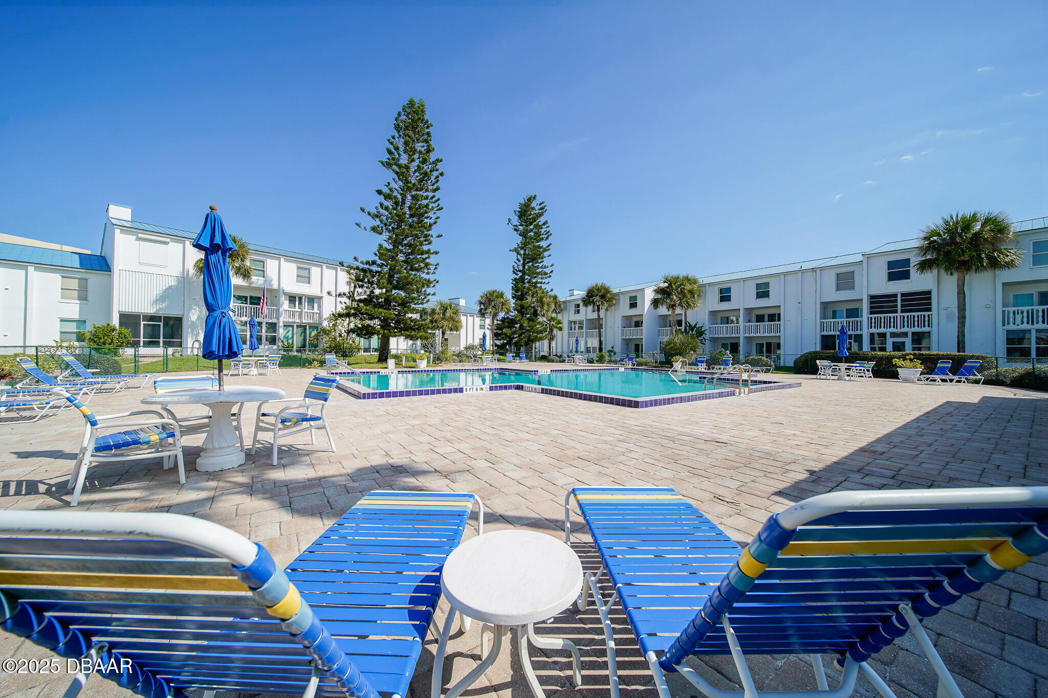 4590 South Atlantic Avenue, Unit 247 Ponce Inlet, FL 32127 - Photo 24 of 36 a swimming pool with outdoor seating and yard in the back