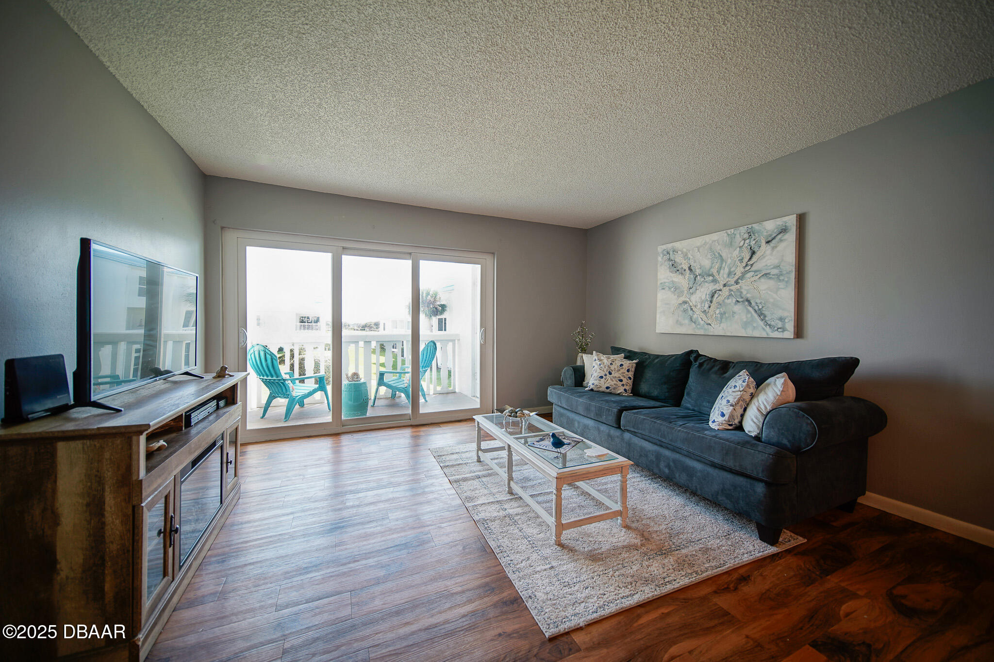4590 South Atlantic Avenue, Unit 247 Ponce Inlet, FL 32127 - Photo 6 of 36 a living room with furniture large windows and wooden floor