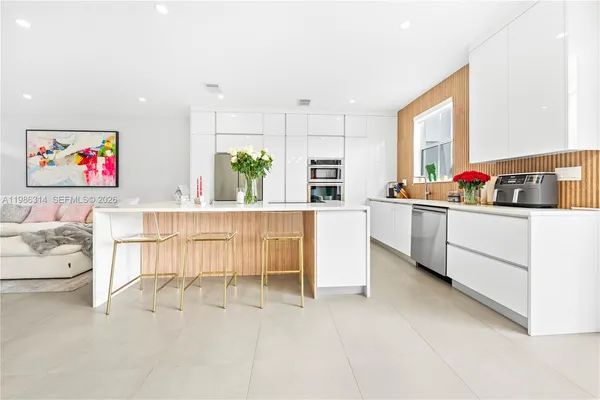 a kitchen with white cabinets and sink