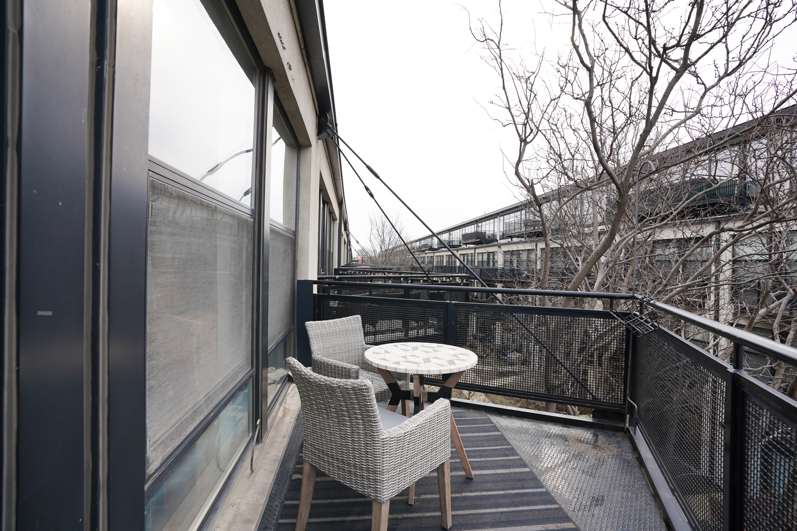 1069 West 14th Place, Unit 303 Chicago, IL 60608 - Photo 17 of 26 a view of a balcony with wooden floor and bench