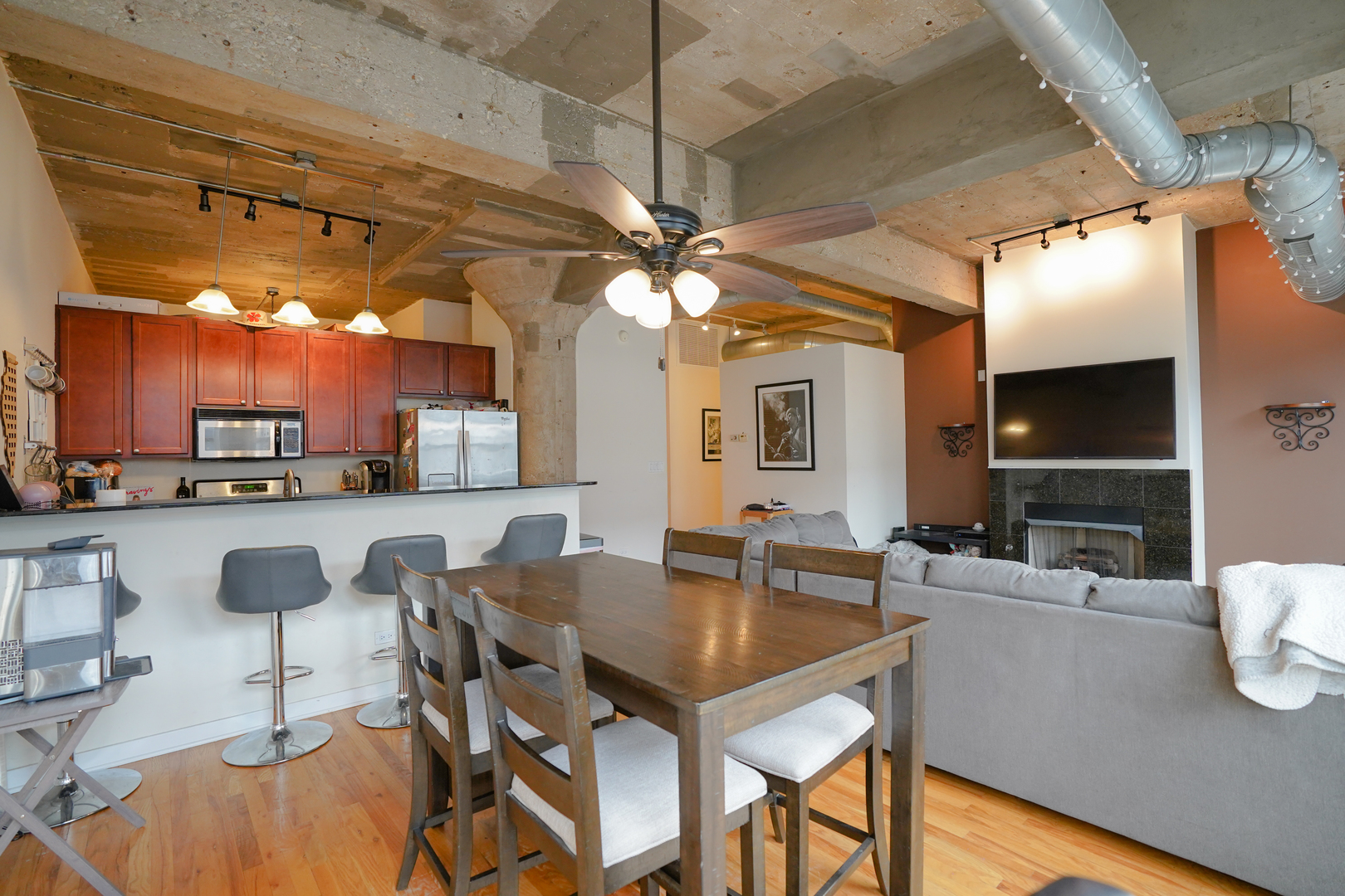 1069 West 14th Place, Unit 303 Chicago, IL 60608 - Photo 5 of 26 a kitchen with a table chairs refrigerator and cabinets