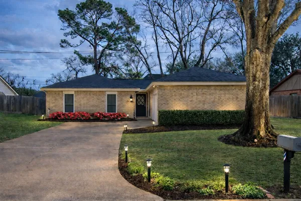 front view of a house with a yard and garage