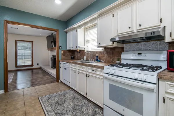 a kitchen with granite countertop a stove a sink and a granite counter tops
