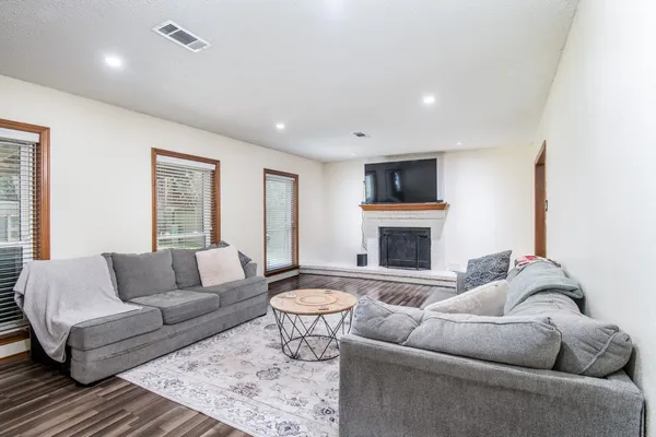 a living room with furniture a fireplace and a flat screen tv