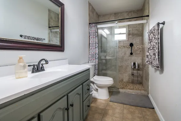 a bathroom with a sink a toilet and shower
