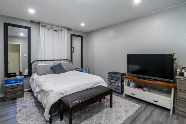 a spacious bedroom with a bed and a flat screen tv