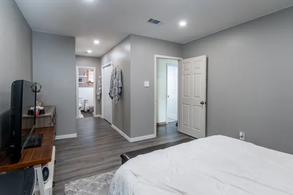 a bedroom with a bed and wooden floor