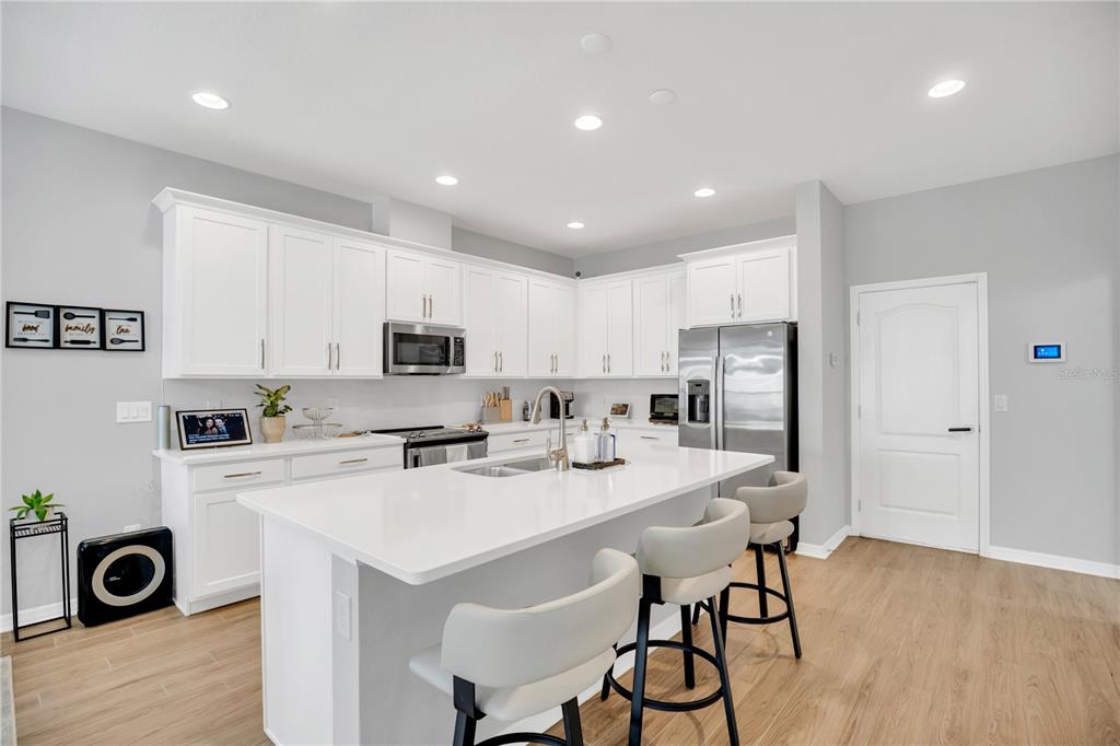 635 Cheval Lane DeBary, FL 32713 - Photo 11 of 33 a kitchen with stainless steel appliances a stove a sink a refrigerator and cabinets