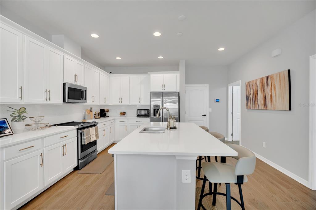 635 Cheval Lane DeBary, FL 32713 - Photo 10 of 33 a kitchen with white cabinets stainless steel appliances and sink