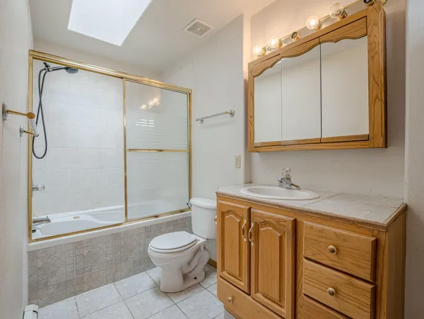 a bathroom with a granite countertop sink toilet and shower