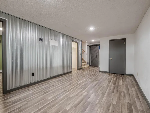 a view of an empty room with wooden floor and entryway