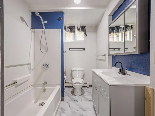 a bathroom with a bathtub sink mirror and toilet