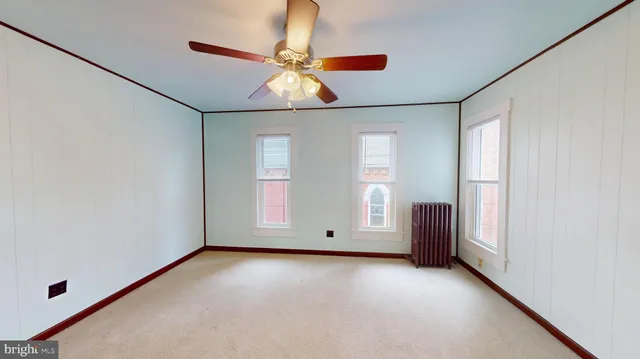 an empty room with windows and fan